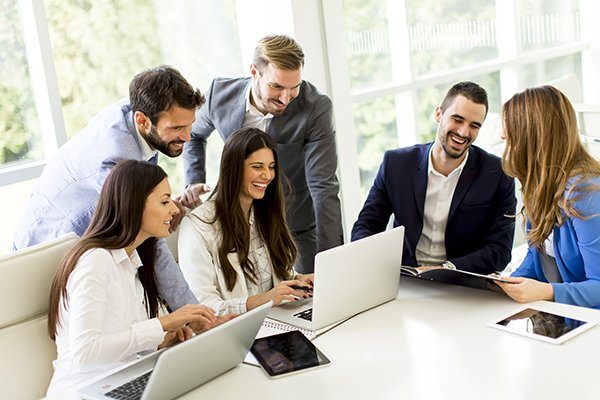 Startup business team on meeting in modern bright office interior and working on laptop